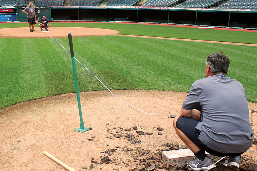 People measuring out ballfield dimensions