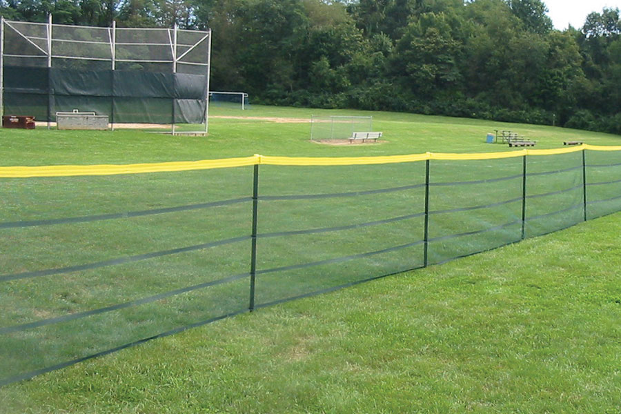 Yellow hem woven along top edge of 4′ high fence for high visibility