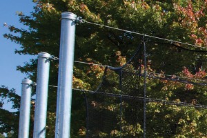 Tensioned overhead cable supports cage — no side poles or overhead structure to cause ball ricochet and no structure to snag or tear netting