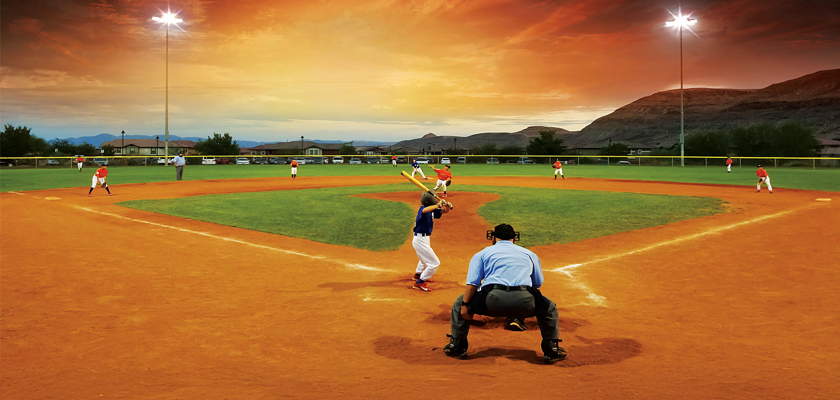 Kids playing baseball at sunset