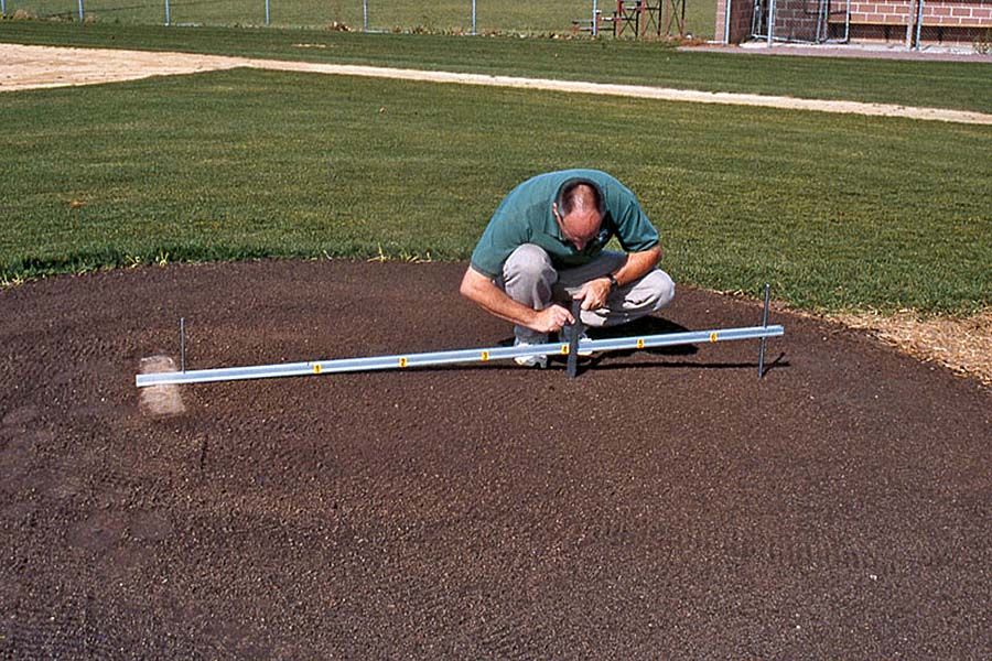 Photo: A groundskeeper measures base distance.
